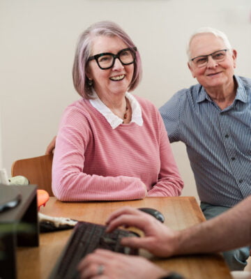 Photo of podiatry clients smiling at a consultation with their podiatrist.