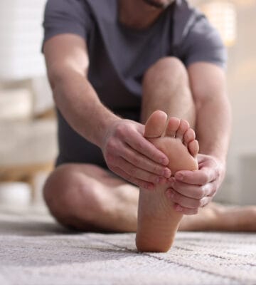 Man holding foot due to pain from problem feet.