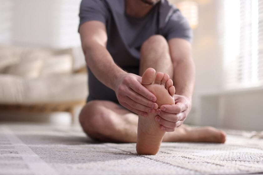 Man holding foot due to pain from problem feet.