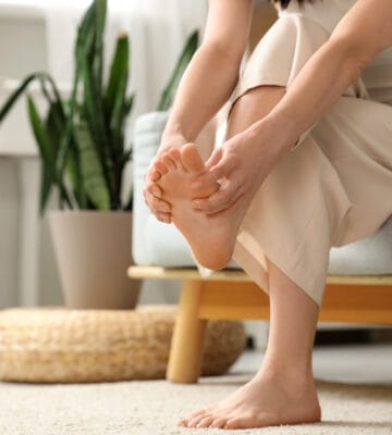 Woman holding and massaging foot due to arch pain