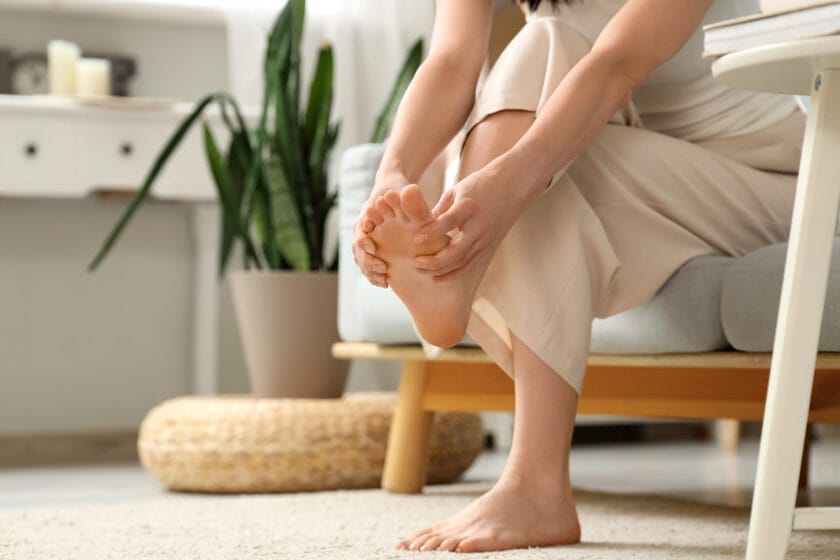 Woman holding and massaging foot due to arch pain